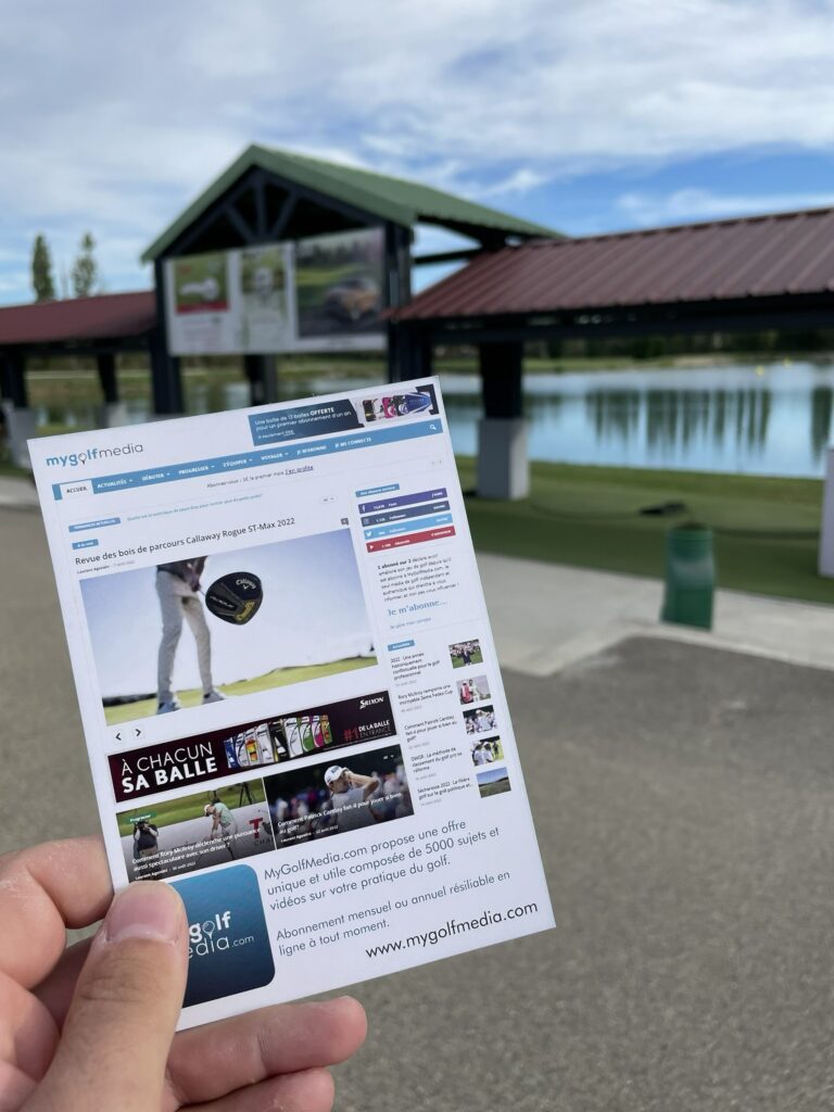 Flyer de promotion MyGolfMedia présenté devant un practice de golf"